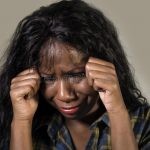 young sad depressed black african american woman crying anxious overwhelmed feeling sick stressed isolated studio b 127611147