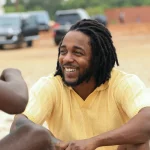 Kendrick Lamar is gearing up for the release of his highly-anticipated new album dubbed Mr. Morale & The Big Steepers. In this regard, he has been in Ghana, and a video of him enjoying a soccer game with people in Ghana has surfaced. While it is not the sort of the great games you would wager on the bettors.com.gh site, it got massive attention globally. Before that, another video of the Compton rapper hanging out in Ghana had already gone viral before his LP’s release. Sunday, May 15th, was when Mr. Morale stepped out to enjoy a soccer match with some Ghanaians. The natives appreciated the gesture and shared the video of the game online. In the clip, Lamar is seen waiting as his teammates fight for possession before he makes a goal attempt. In another part of the footage, K Dot is seen posing for a group photo with others who took part in the game. Lamar wore a yellow t-shirt and red shorts, and you can see behind the players in the videos a wall covered with murals. One of the murals was of iconic rapper Tupac Shakur whose voice features on Lamar’s album To Pimp Butterfly. It is not clear how long Lamar has been in Africa, but according to rumors, the rapper was visiting Ghana to host an exclusive listening party before the release of his album. Others claim that he is filming a documentary in the country. Apple Music claims that Kendrick Lamar’s fifth solo studio album is smashing records on the platform. In a tweet, the streaming platform wrote that Lemar’s new album recorded the most first-day streams for an album released in 2022. Lemar will also be going for a world tour surrounding his new LP. The tour, dubbed The Big Steppers Tour, will span 65 dates and kick off on July 19th in Oklahoma City. It will then close in Australia in December. Some reports claim the multi-award-winning rapper has been in Ghana for about a week and has visited several locations across the City. Several videos have shown the rapper having a great time as he gets to know the people and their culture. For example, he is said to have visited a skate park. Another video that has gone viral is of Lamar playing video games with young Ghanaian kids. He is captured wholly focused as he enjoyed the video games. It is understood the game they were enjoying was the popular soccer video game – EA Sports FIFA, at a local game center with a group of young children.